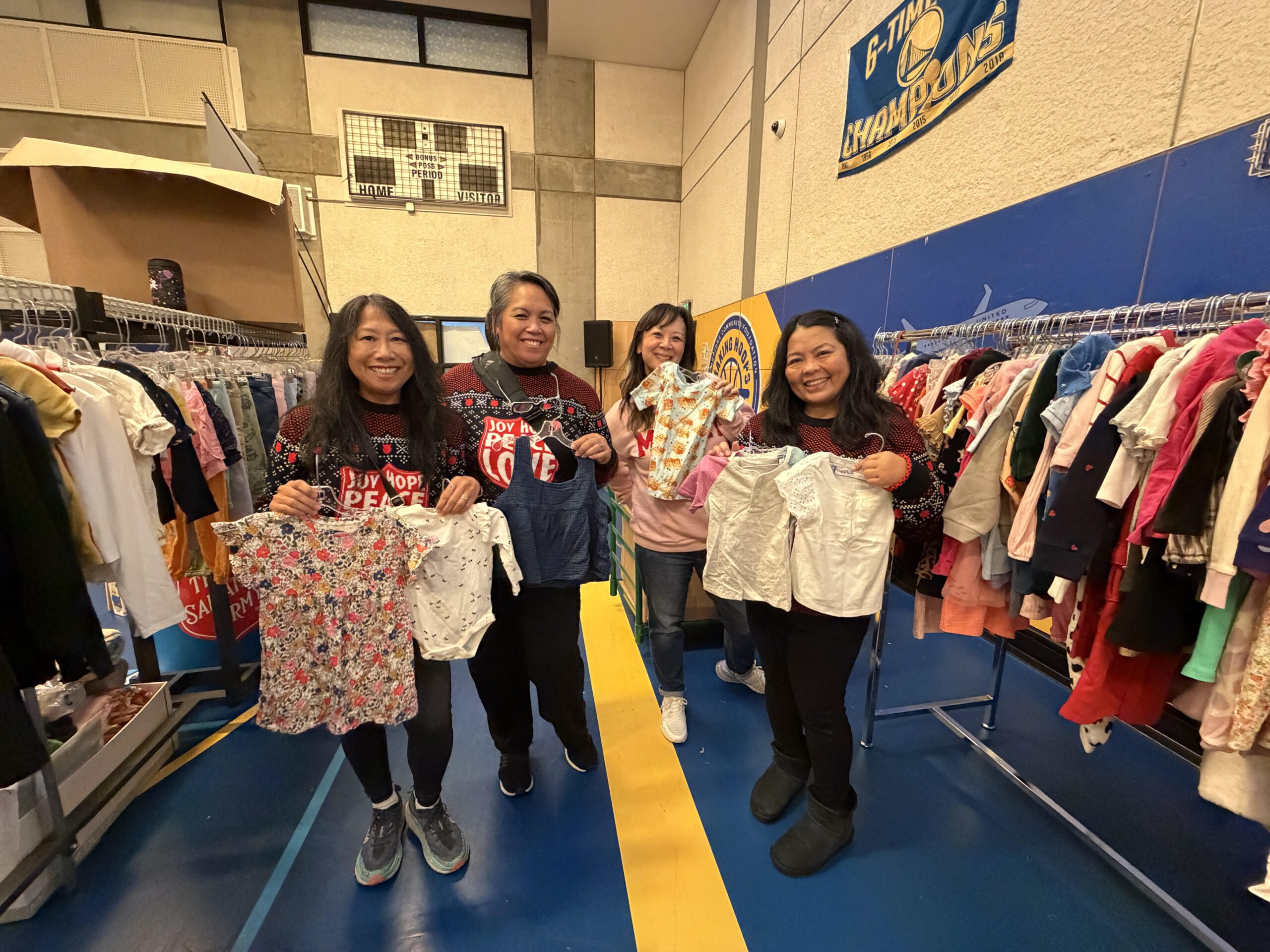 義工Annie(左一)和Maria(右一)參與救世軍「天使樹」計劃多年,協助整理與分類童裝,將節日服務視為回饋社區的家庭傳統。記者蘇婕雅攝