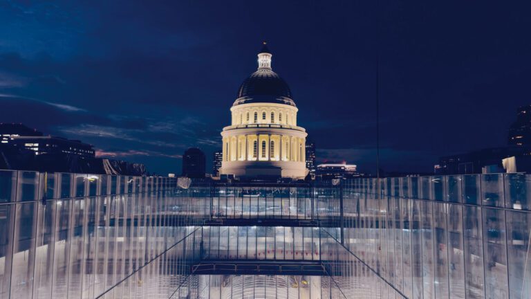 州議會近日公佈州府大樓附樓項目的工程進展，圖為夜色中的新項目外牆玻璃建築，背景為州議會大樓。官網