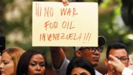 在委內瑞拉，抗議者手持標語牌，反對美國封鎖進出委內瑞拉的油輪。路透社