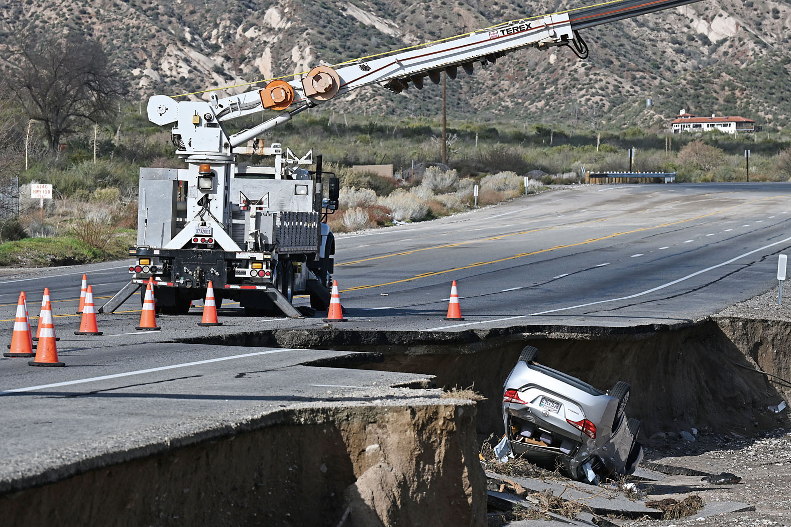連場風暴後,費蘭(Phelan)有道路嚴重受損,一輛汽車翻覆在受損道路旁。美聯社