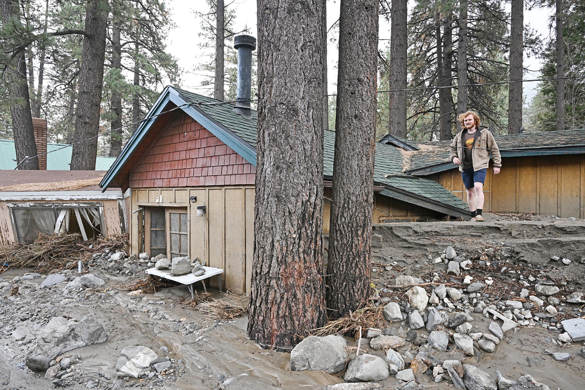 賴特伍德山泥傾瀉掩埋民房,居民施奈德(Davey Schneider)周四走在被泥土掩埋的住屋屋頂上。美聯社