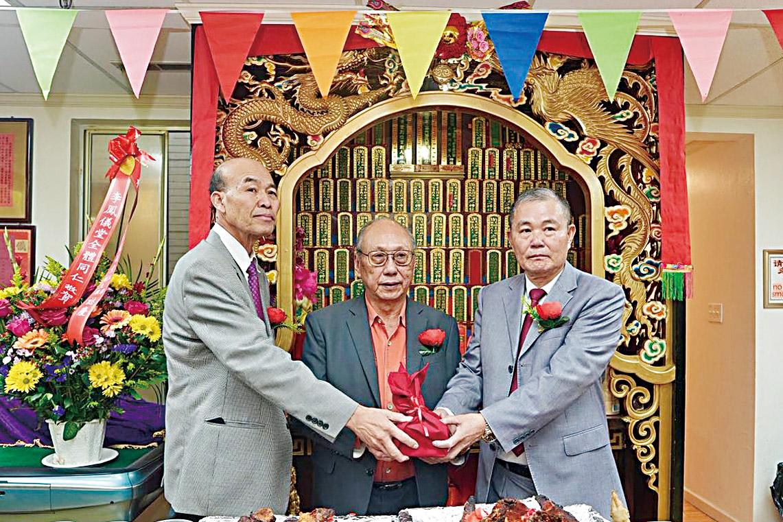 元老李彪（中）主持監交，新任主席伯謀（右）從滿任主席羨湛（左）手中接印履新。蕭強攝