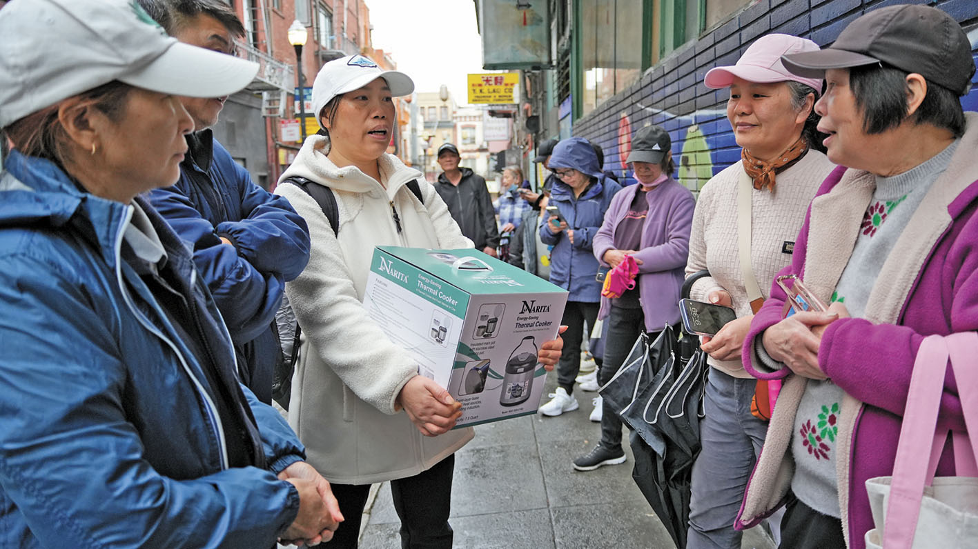 喜獲節日禮物的居民,與排隊輪候的居民分享喜悅。記者黃偉江攝