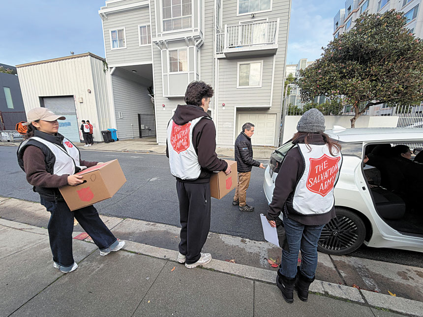 救世軍義工於聖誕清晨在烹飪藝術培訓學院集合，將可加熱的節日餐點裝箱，準備分組出發前往長者住所派送。記者蘇婕雅攝