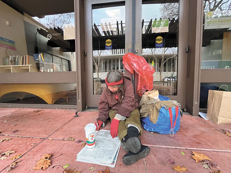 無家者Naomi坐在波羅阿多市市中心圖書館的大門前等待過夜取暖處開門。記者王蔚攝