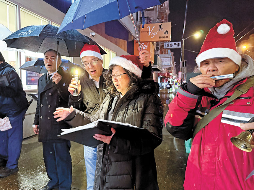 救世軍華埠堂及其他教堂的教友,頂著風雨,高唱聖歌。記者黃偉江攝