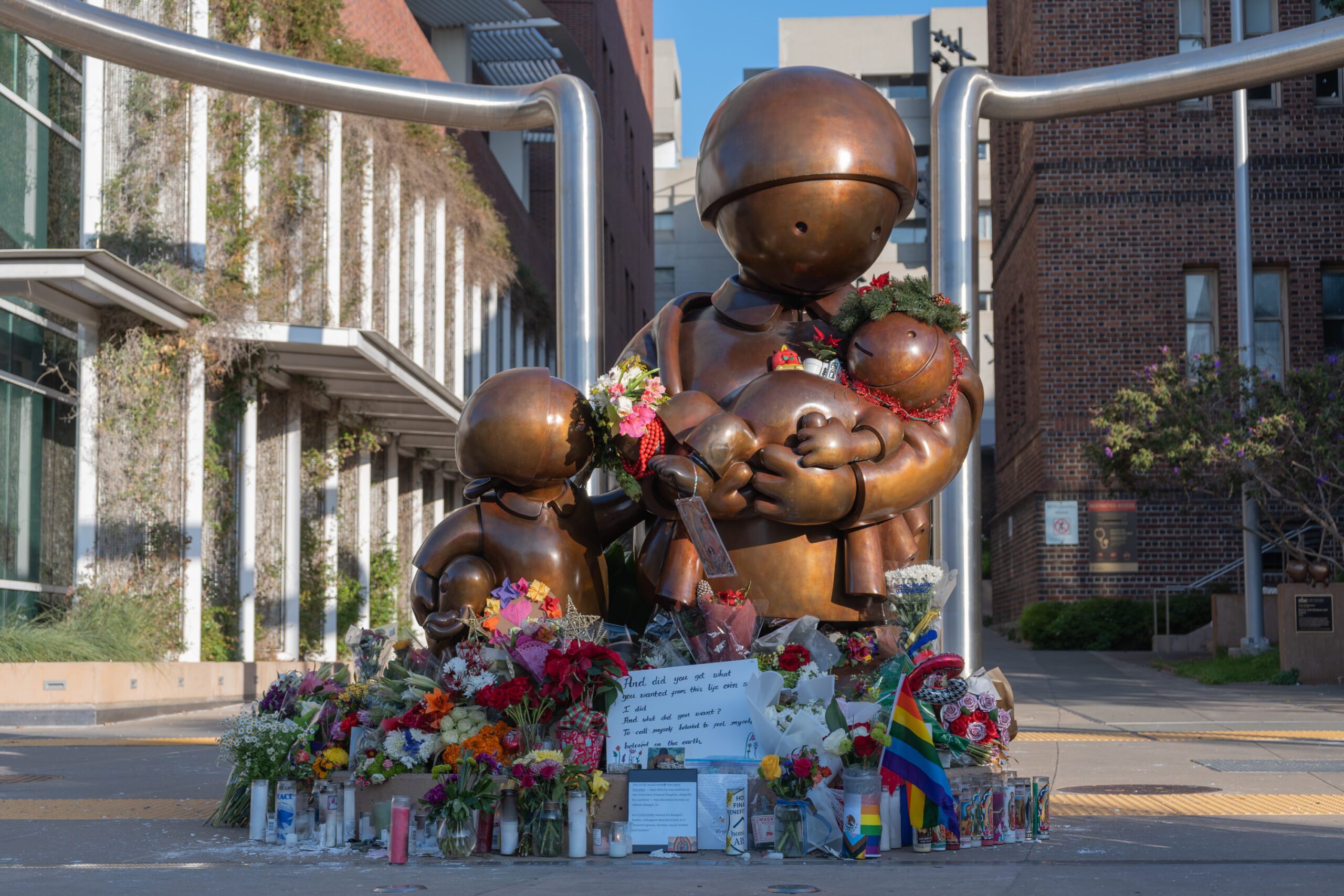 三藩市總醫院外銅像前擺放了鮮花物品悼念社工蘭格爾。灣區城市新聞社