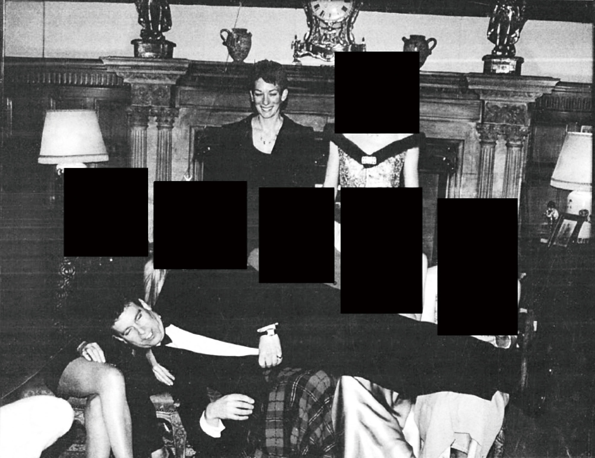 司法部公開一張經遮蓋處理的黑白照片,安德魯王子橫躺在多名女子腿上,麥克斯韋爾站在背後微笑。司法部/美聯社