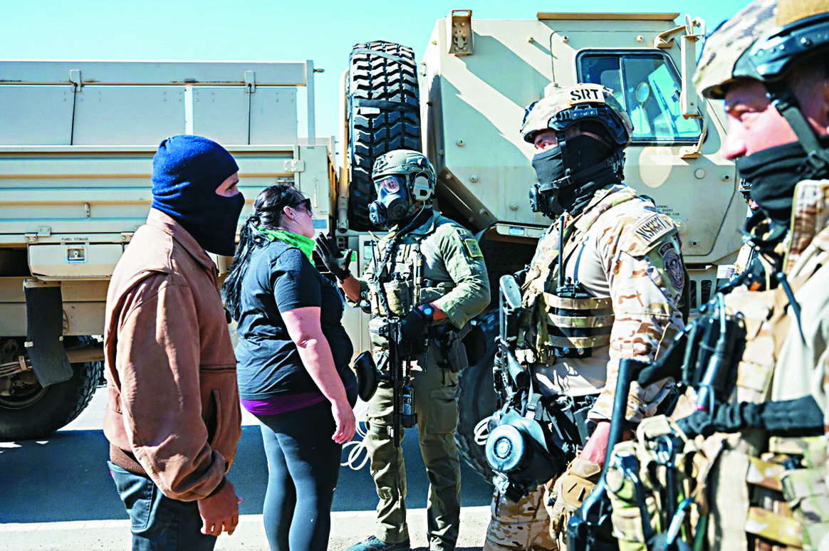 今年7月美國移民及海關執法局(ICE)特工在南加州卡馬里奧(Camarillo)與抗議民眾對峙。美聯社