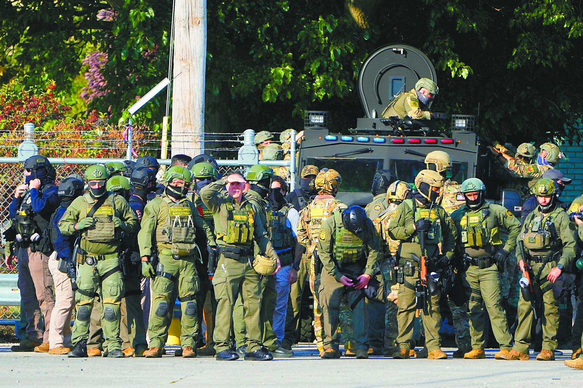 美國邊境巡邏隊與聯邦移民執法人員站在伊利諾伊州的移民和海關執法局設施附近。美聯社