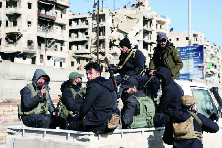 敘利亞政府軍表示，已在阿勒頗希克馬述區完成「安全掃蕩」。圖為政府軍坐在車上經過該地區。路透社