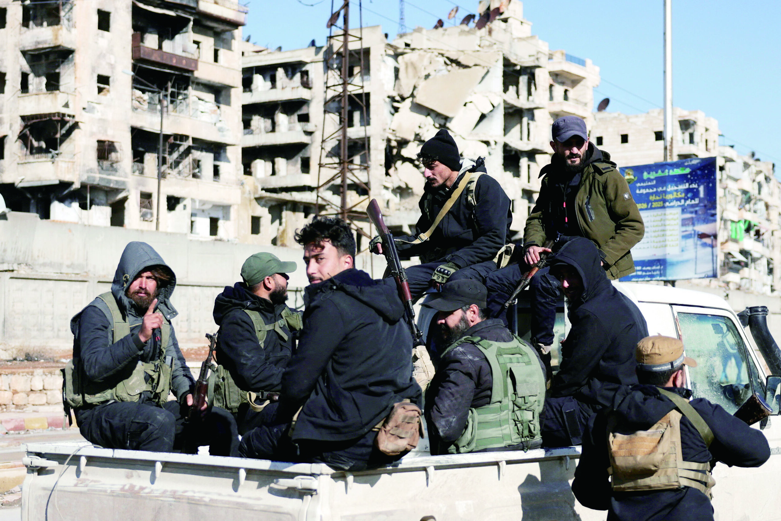 敘利亞政府軍表示，已在阿勒頗希克馬述區完成「安全掃蕩」。圖為政府軍坐在車上經過該地區。路透社