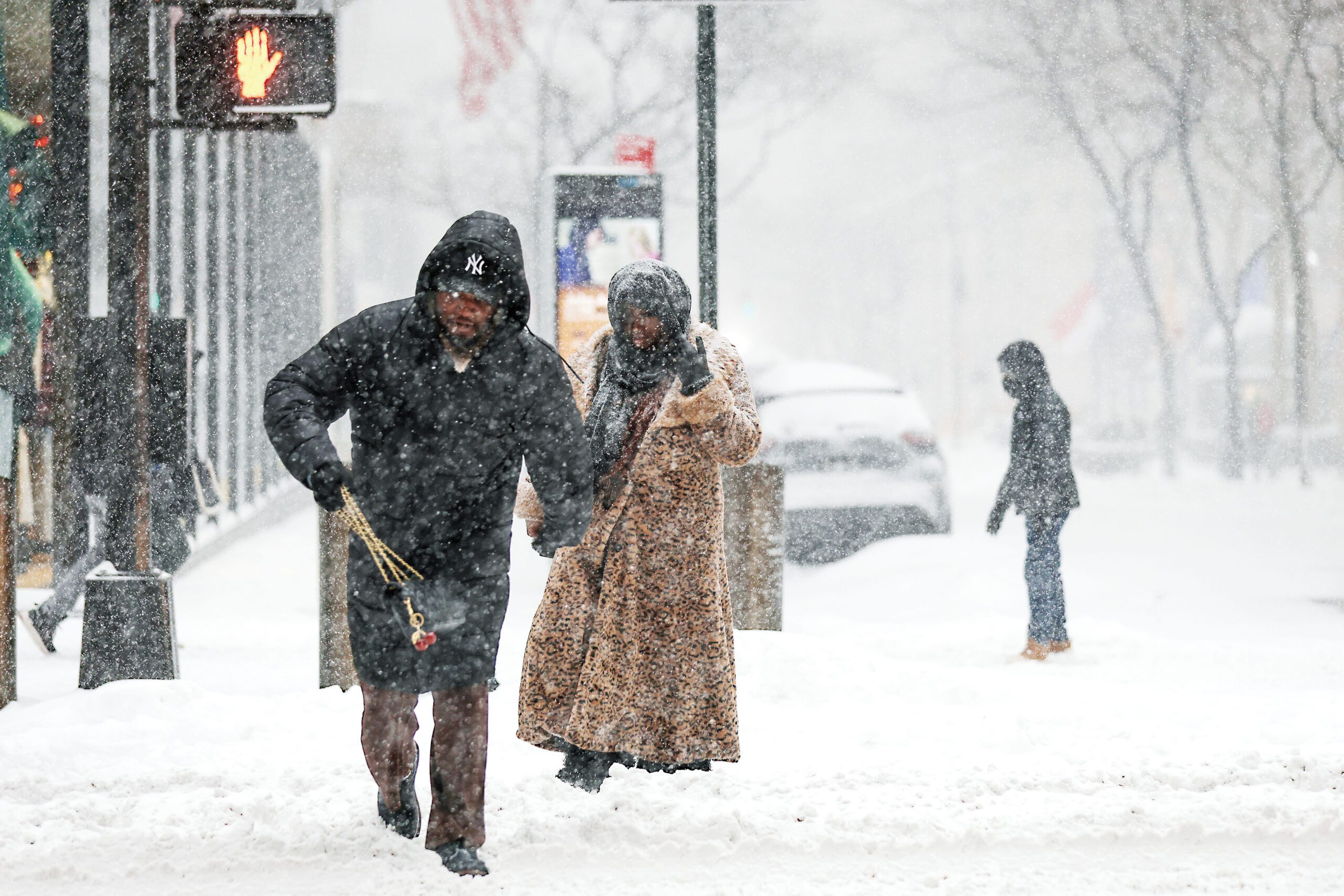 超強冬季風暴席捲大部分地區，凍雨暴雪導致交通大規模癱瘓。圖為紐約行人冒著暴風雪過馬路。美聯社
