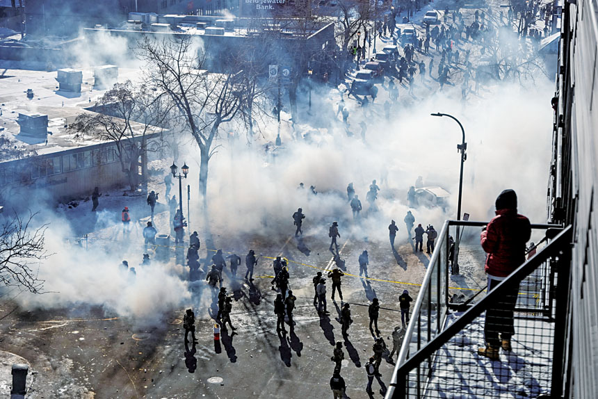 居民站在陽台上看聯邦執法人員與社區居民在催淚瓦斯的煙霧中衝突。路透社