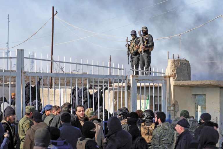 敘利亞政府軍與「敘利亞民主力量」發生衝突，導致被關押的IS成員趁亂越獄。圖為敘利亞政府軍21日在霍爾營地站崗，一群被拘留者聚集在此。路透社