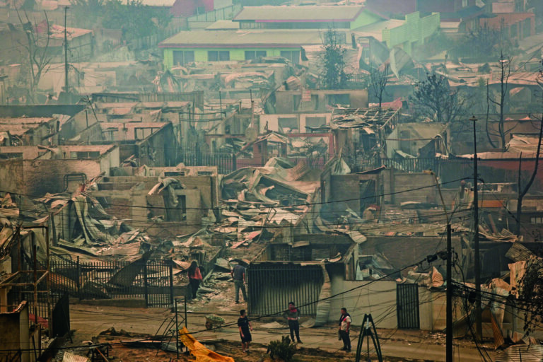 比奧比奧大區民眾緊急疏散。圖為人們站在被燒毀的房屋間。路透社