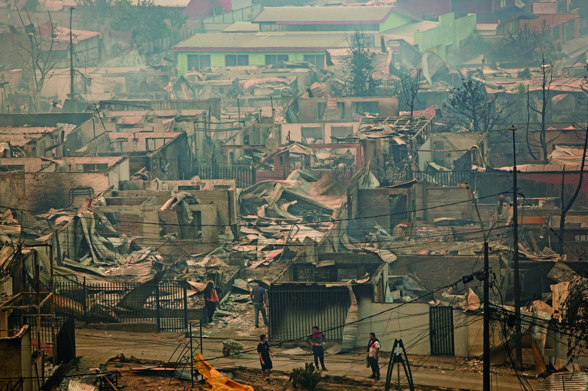 比奧比奧大區民眾緊急疏散。圖為人們站在被燒毀的房屋間。路透社