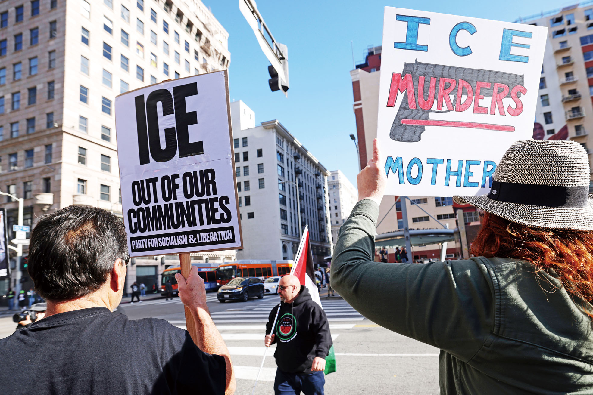 示威者舉牌指斥ICE謀殺母親，要求ICE停止行動還社區安寧。美聯社