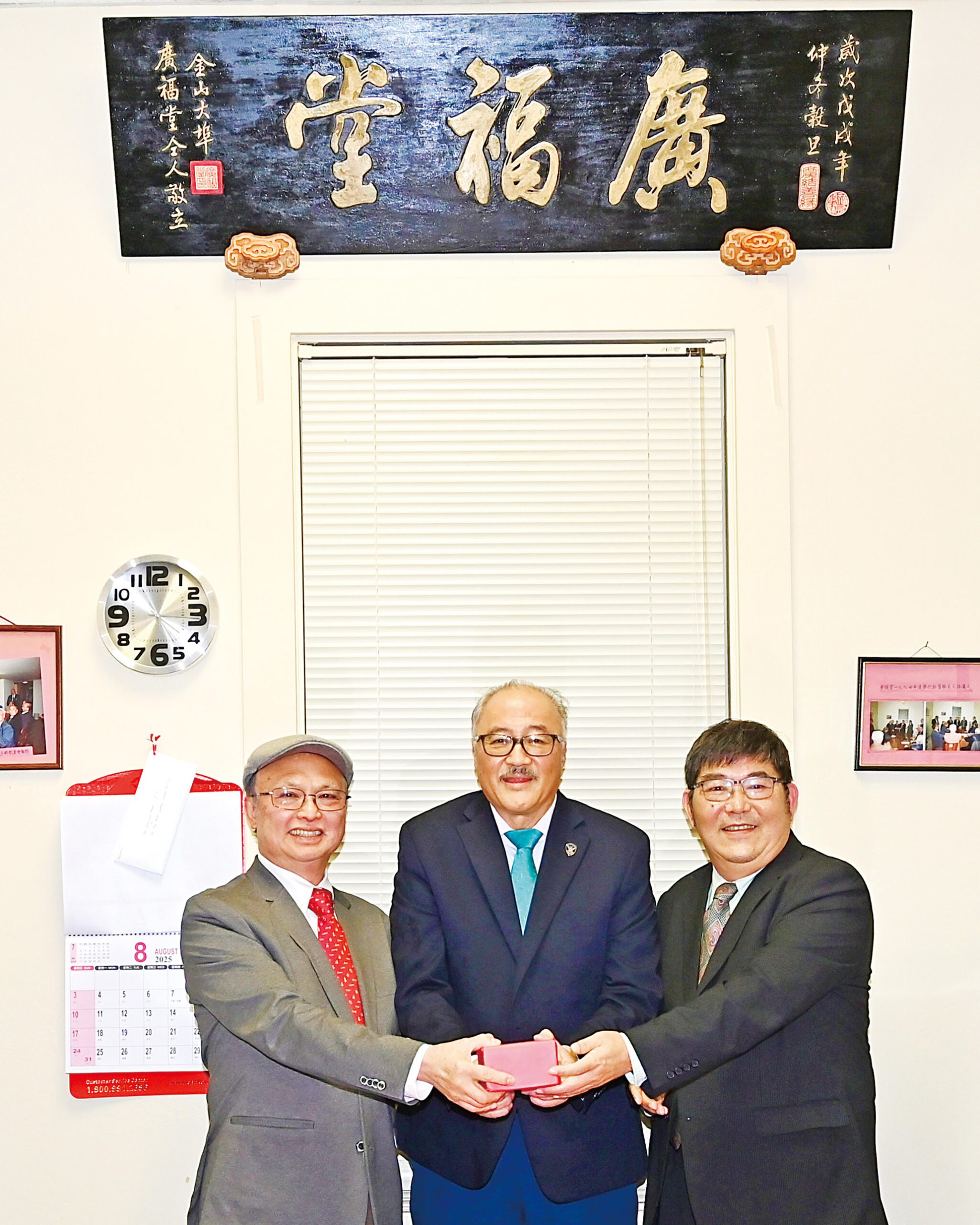 前任主席余健全（中）主持監交，新任主席余健峰（左）從滿任主席吉鴻雁（右）手中接印承責，繼往開來，努力推展堂務工作。馬紅兵攝