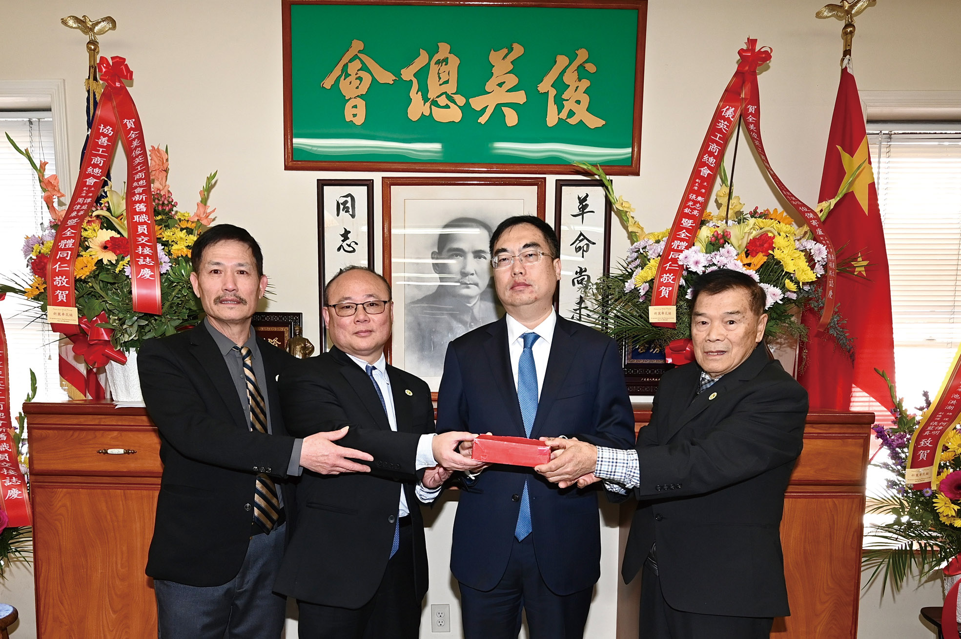 中領館領僑處主任王一鳴(右2)主持監交,連任總理鄭佩恆(右1)、新任副總理蕭子浩(左2)與滿任副總理李漢文(左1)順利交接,正式視事,為俊英工商總會服務。馬紅兵攝