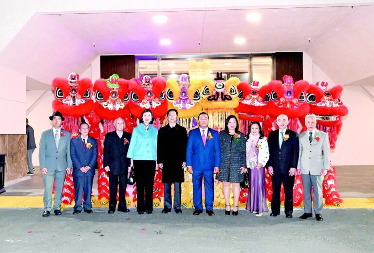 中領館總領事張建敏暨夫人鄭心親臨，與新任主席黃建成、秘書廖伽敏；滿任主席陳國慶、秘書黃漢傑；顧問盧偉棠、何東石及理事陳展明在醒獅前合影。馬紅兵攝