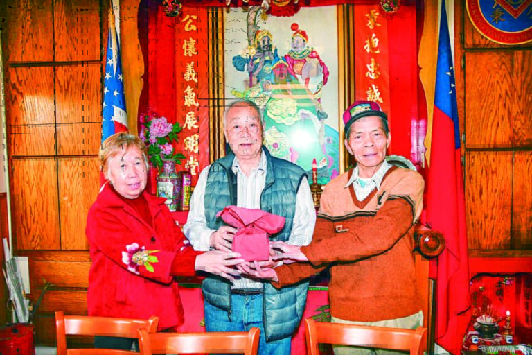 在監交人林丕燊元老（中）的監交下連任主席李國暉（右），副主席李心馨（左）接過印信覆新就職。譚國亮攝