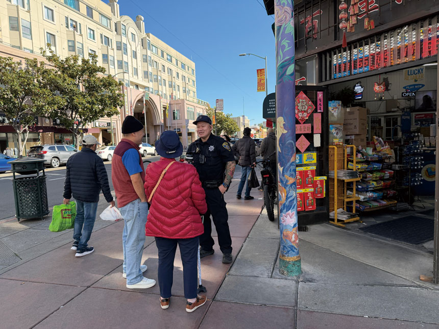 駐守華埠多年的警員在街頭與居民交談，熟悉社區的警務互動被商戶形容為「看得見的安全感」。記者蘇婕雅攝