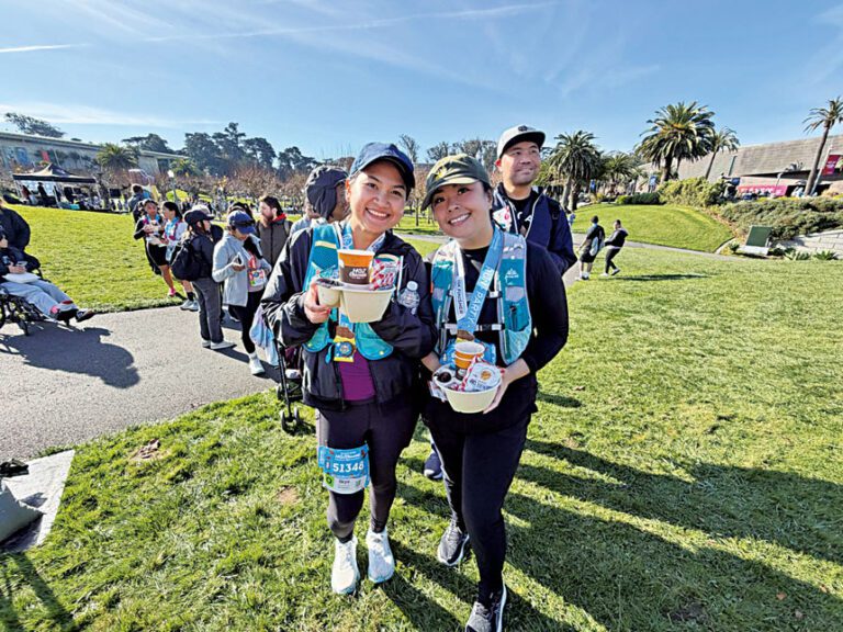 完成15K的跑者Skye（左）與Des（右）手捧熱巧克力拍照留念，為冬季路跑劃下甜蜜句點。記者蘇婕雅攝