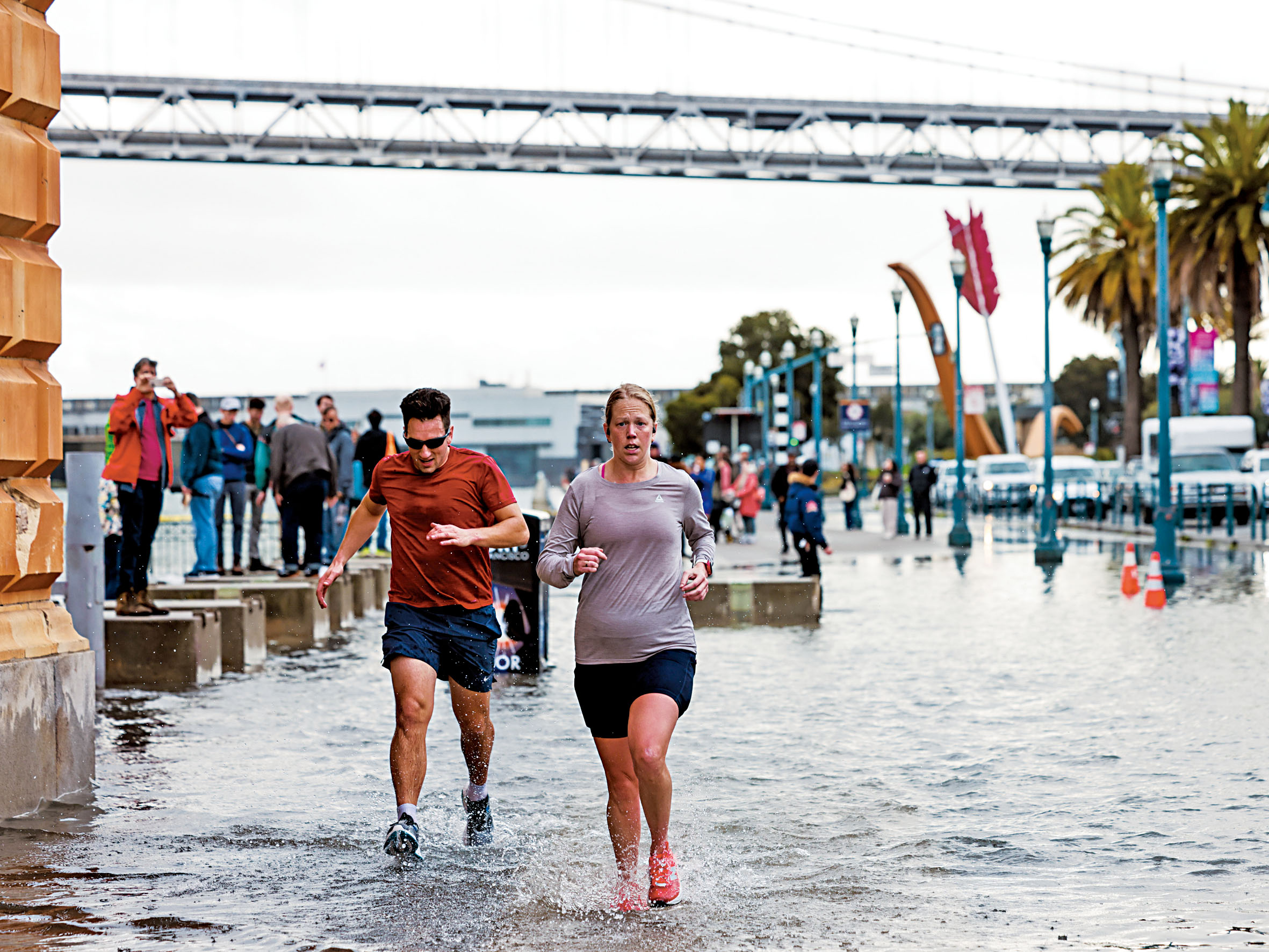 三藩市渡輪大樓一帶出現水浸，跑步人士踏水前行。Yalonda M. James/三藩市紀事報/美聯社
