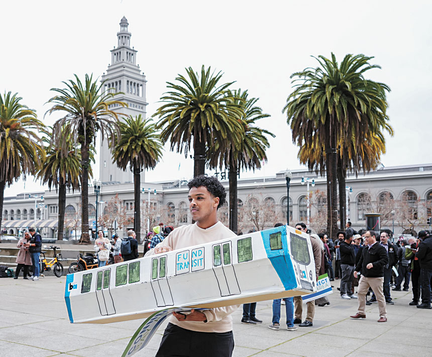 支持資助公共交通系統的集會上，參與者高舉紙板捷運。灣區城市新聞社