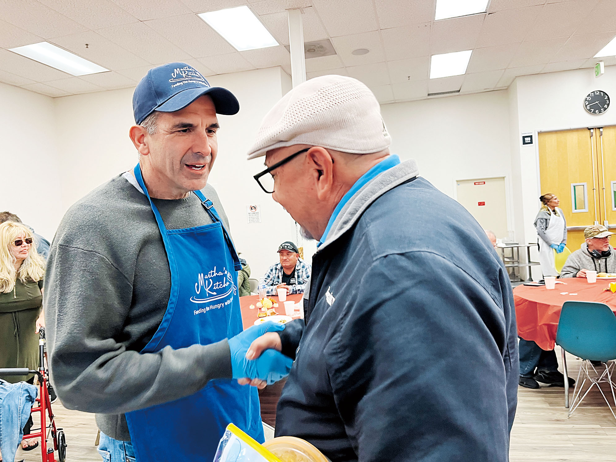 圖為聯邦眾議員李卡多2025年11月在南灣瑪莎廚房參加感恩節熱餐派送時與居民互動。本報資料圖片/記者王蔚攝