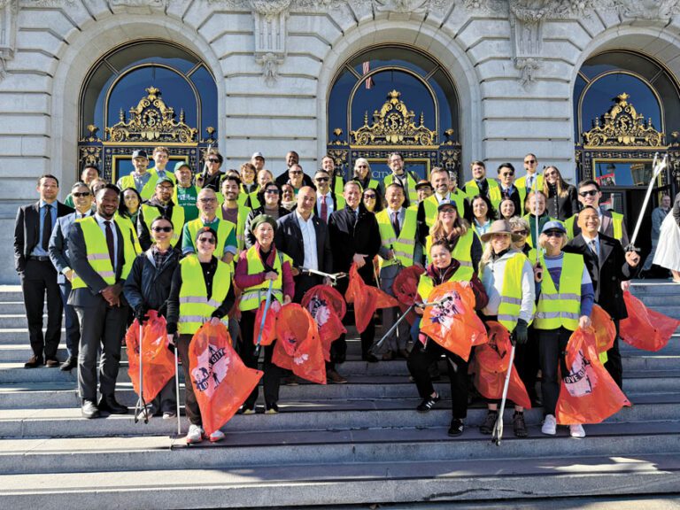 市長羅偉與數十名社區志工及市府人員在市政廳階梯前合影留念，以社區清潔行動紀念上任一周年。記者蘇婕雅攝