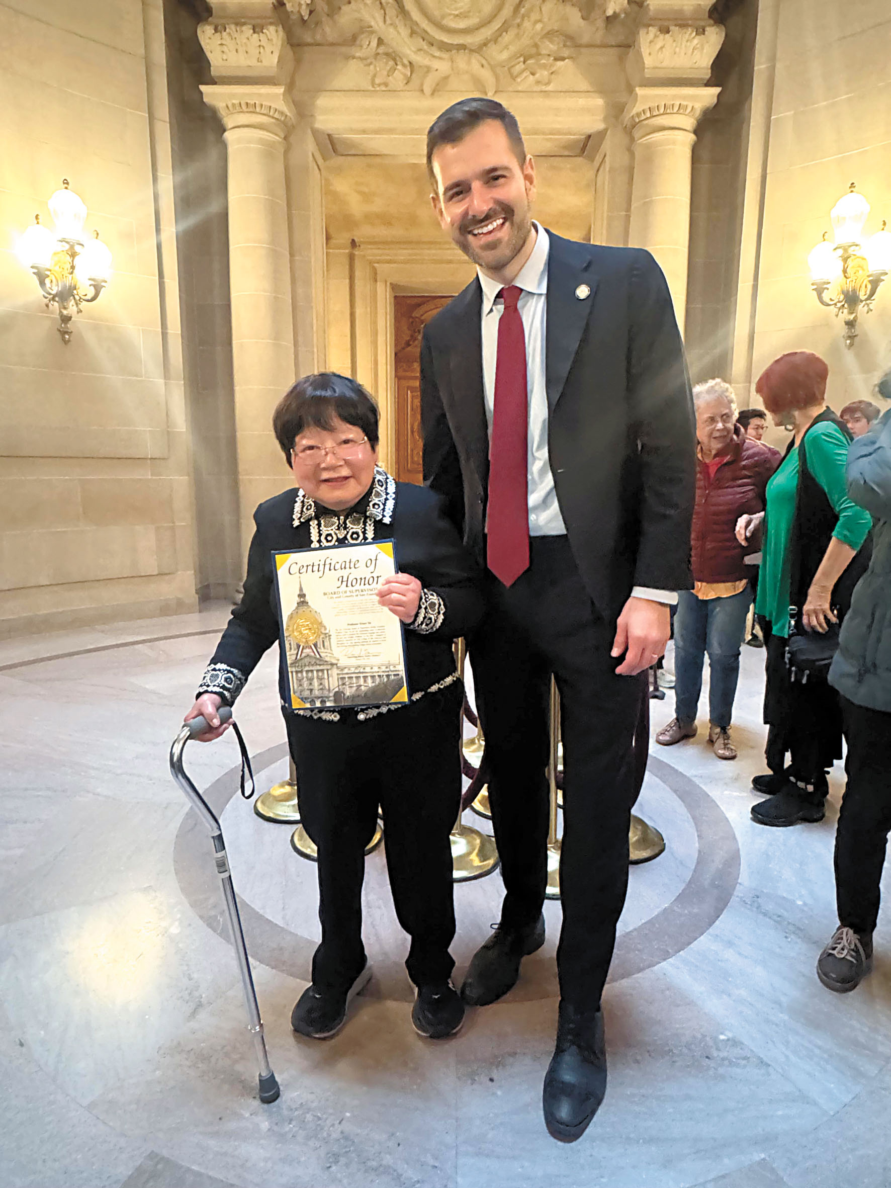 市參事李爾德(右)與獲表彰的市立大學粵語教師余天璇(左)合影留念,表彰其長年培育公共服務粵語人才、守護華人語言文化的貢獻。市參事辦公室提供