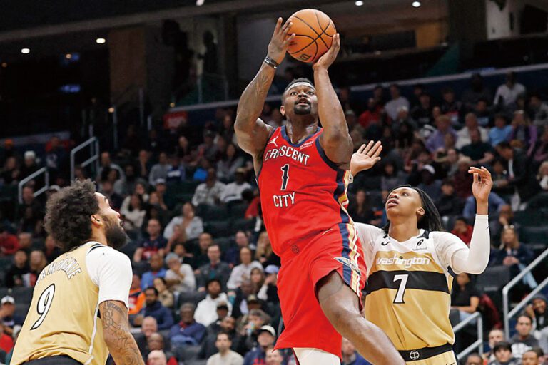 鵜鶘隊前鋒錫安（中）突破奇才球員夾擊投籃得分。路透社