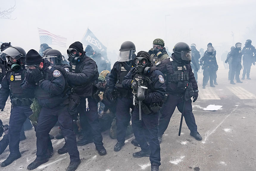 特朗普總統威脅動用《叛亂法》，派軍明尼蘇達州。圖為聯邦移民執法人員在明州聯邦大樓外與示威者對峙。美聯社