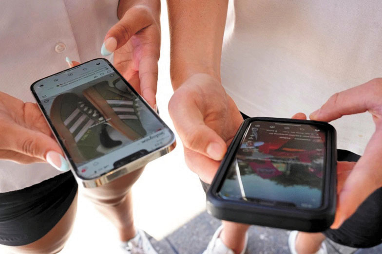 年輕人使用手機瀏覽社群媒體。美聯社