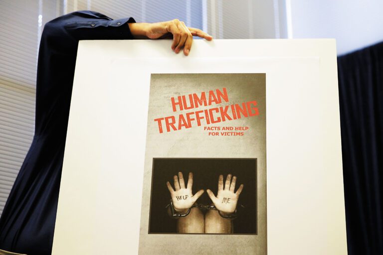 圖為過去長堤市府人員展示打擊人口販賣性交易看板。美聯社資料圖片