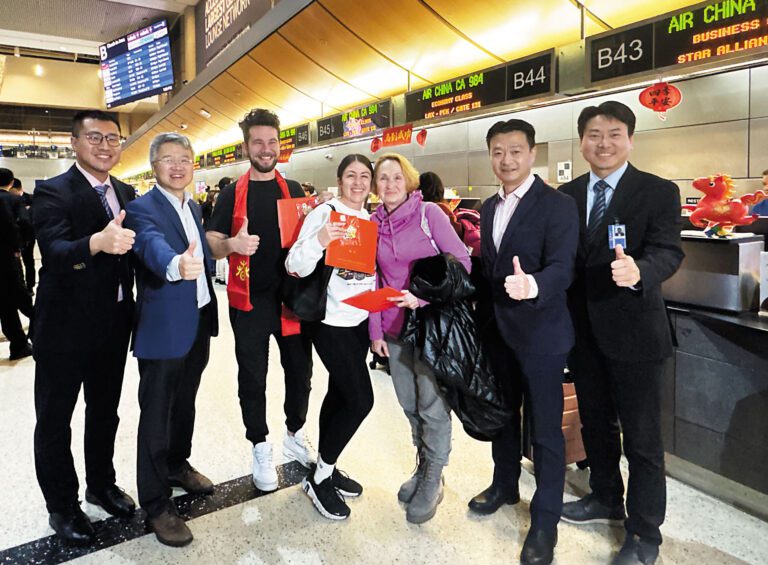 彭雷 (左2) 在值機櫃檯前為乘客頒發新年禮物送祝福。記者陸新攝