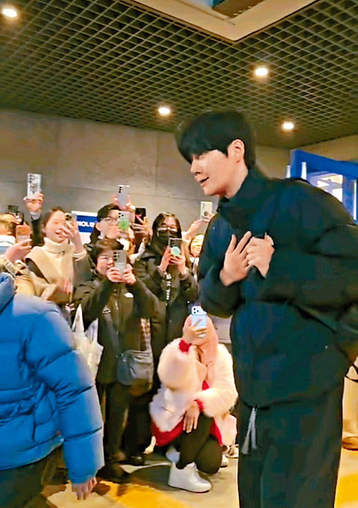 粉絲在劇場門外等金宣虎下班，他則一直向他們鞠躬道謝。