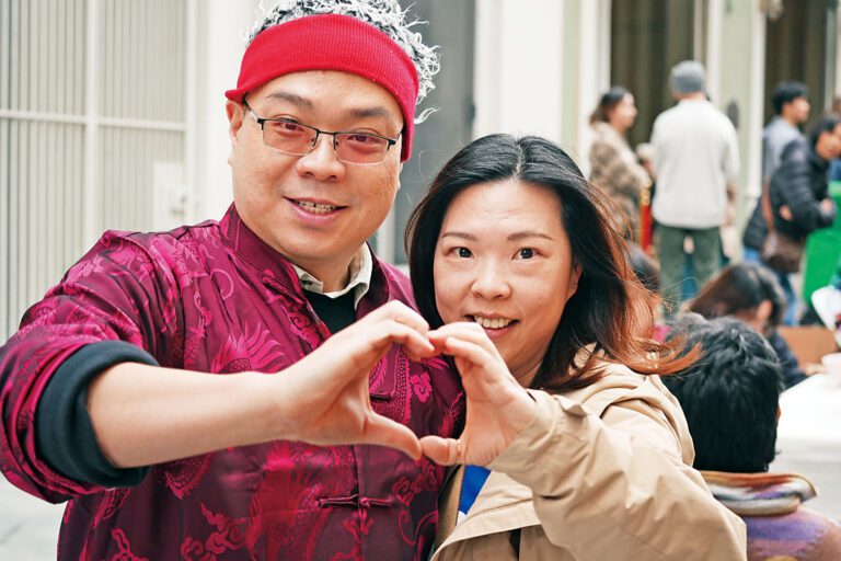 情人節正日新僑服務中心主任陳浩源與親密女友來到相親角現場做手勢示愛。記者黃偉江攝