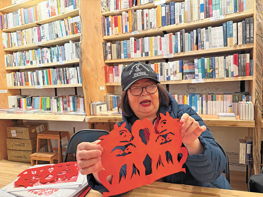 天后廟街新開張的格外書店邀得知名剪紙藝術家侯玉梅現場創作馬年剪紙。記者黃偉江攝