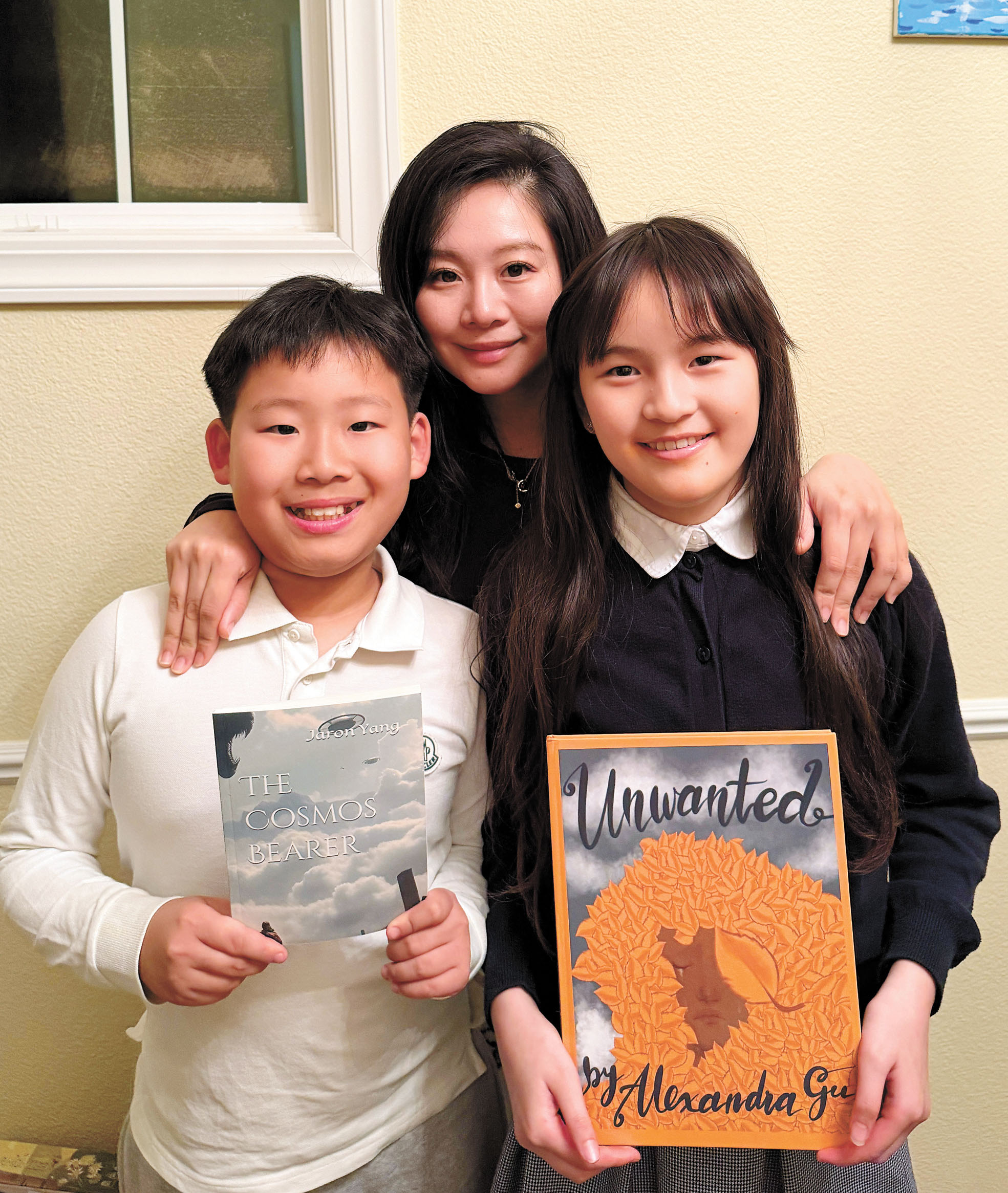 AAEG創辦人胡女士與兩名小作家Jaron Yang（前左）及 Alexandra Gu（前右）合影，展示他們出版的小說作品。受訪者提供