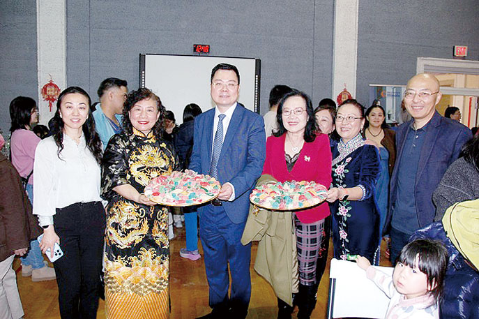 中國駐芝加哥總領館王義參贊（左3）、芝加哥人民藝術團團長劉曄（左2）、美亞健康協會主任劉紅（右3）與嘉賓們展示餃子。 主辦方提供