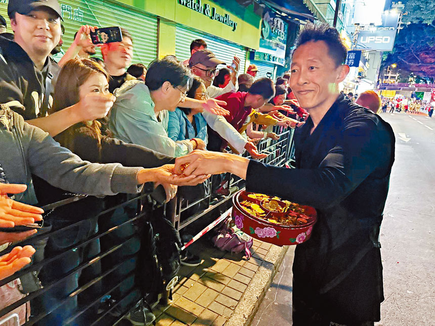 小齊表演之餘，更與兩旁的觀眾親民打招呼。