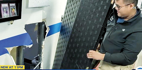 店主展示竊賊們破壞兩店間的石膏牆後闖入行竊。ABC7電視畫面