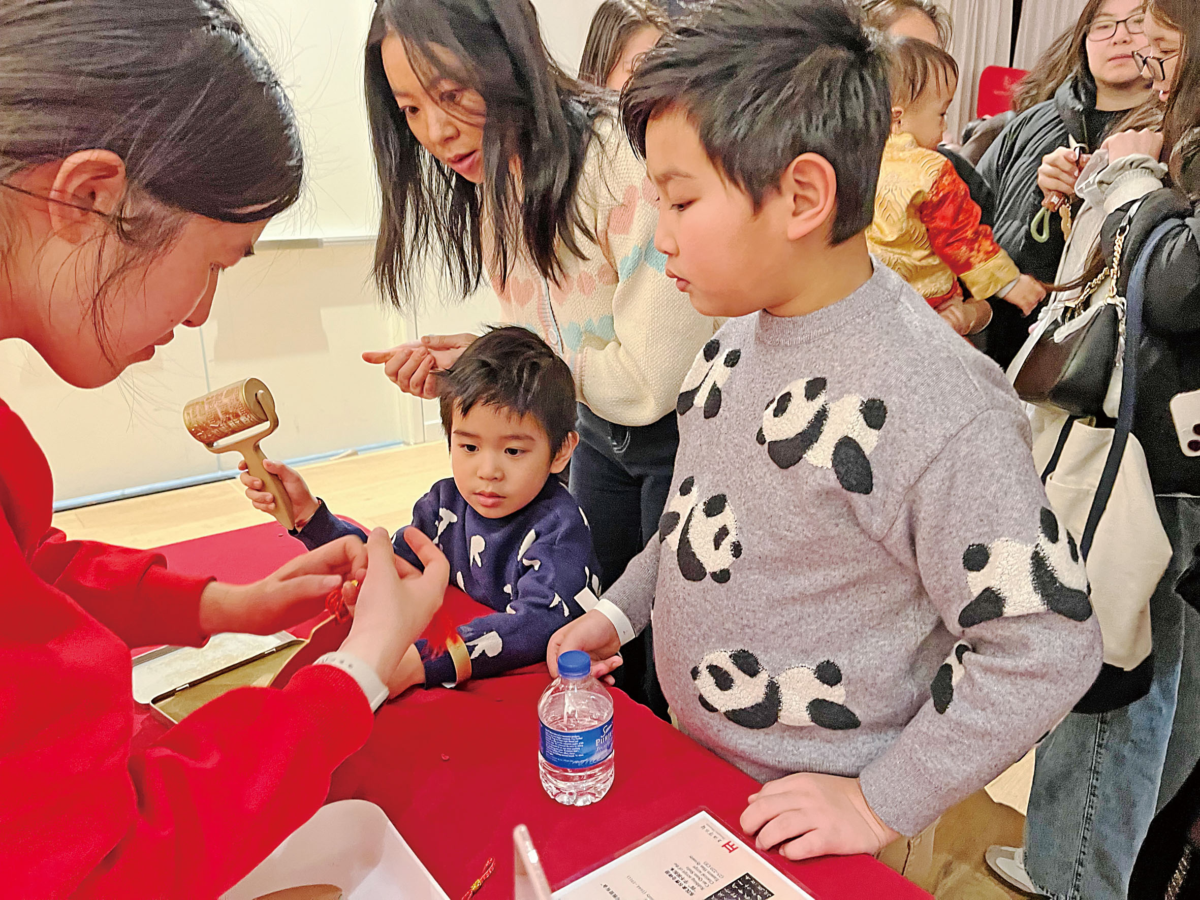 陳苗苗帶著兩個兒子學習製作福字掛飾。