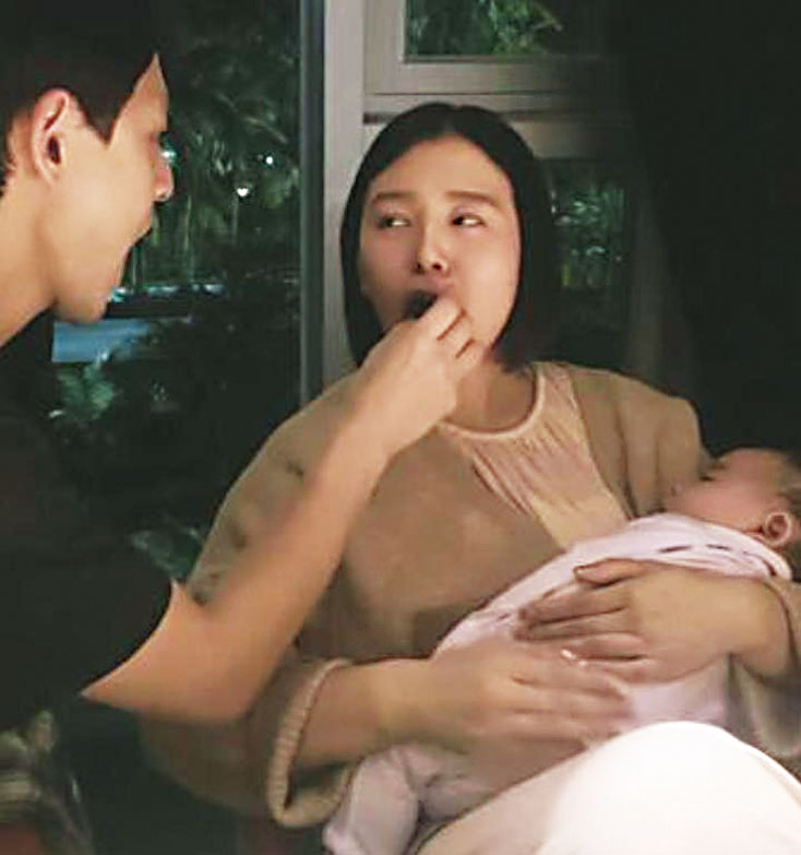 劉品言抱著女兒，張開嘴接受老公的投餵。網上圖片