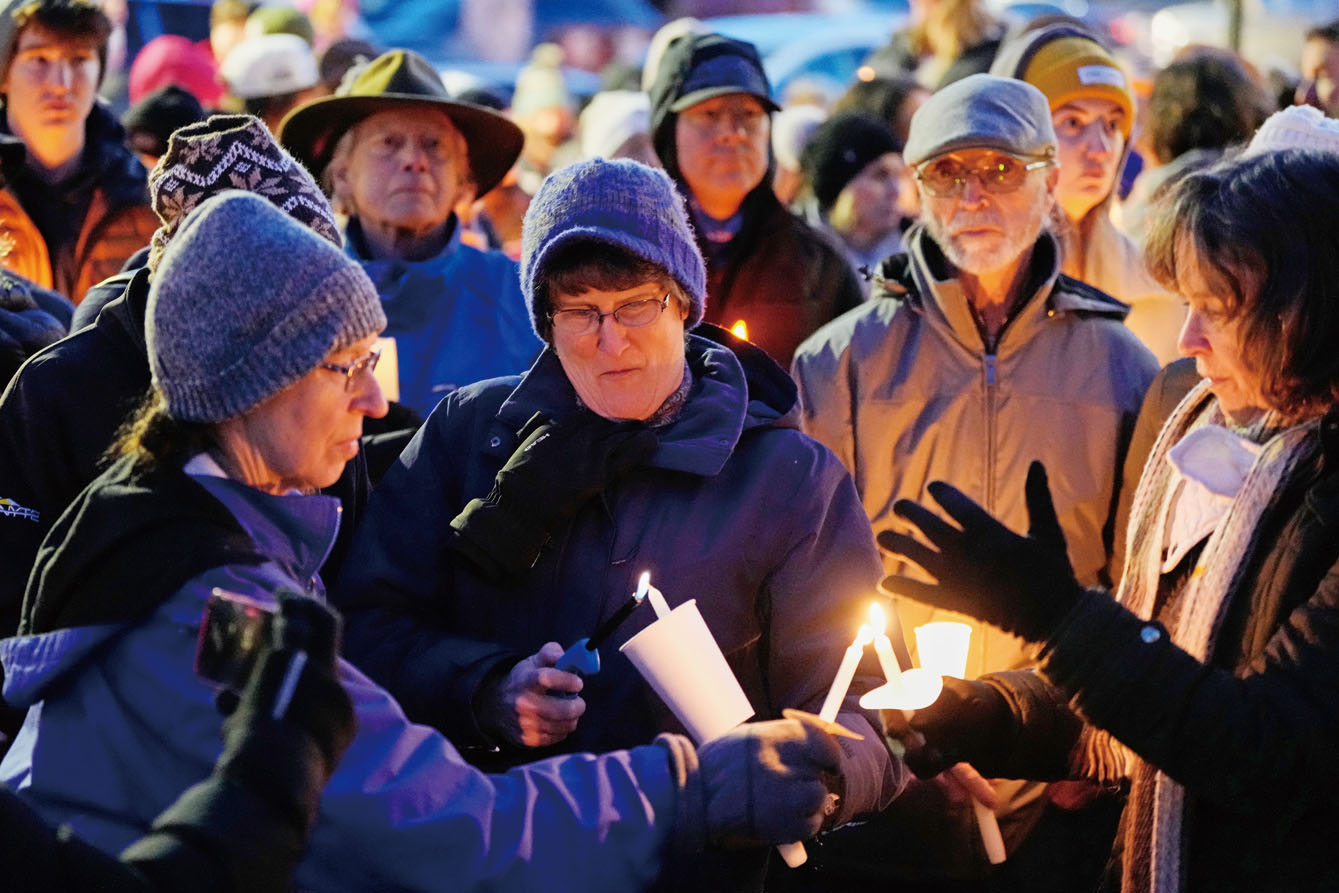 圖為民眾點燃蠟燭表情哀傷。