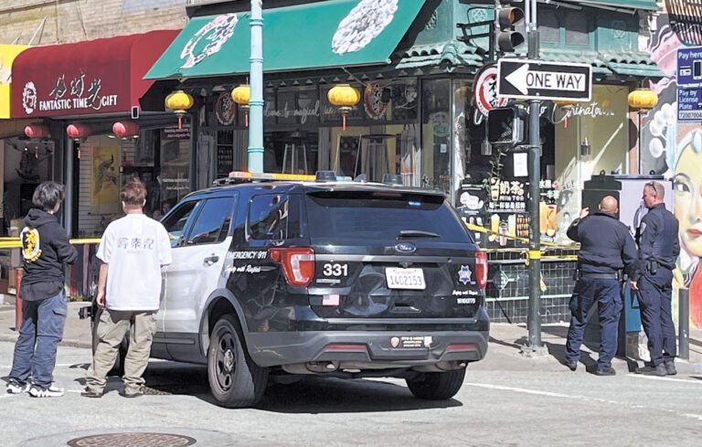 都板街夾華盛頓街街角店鋪23日中午發生開槍案，三藩市警方封鎖現場。讀者提供
