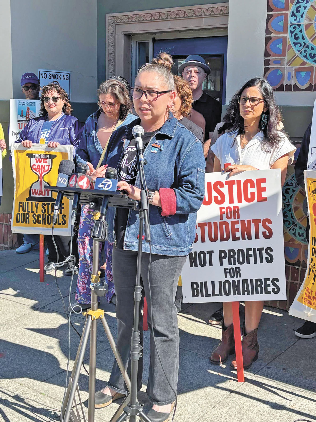 三藩市教師工會主席柯里爾在Francisco中學外公布合約表決結果，教師與家長手持標語聲援。UESF提供